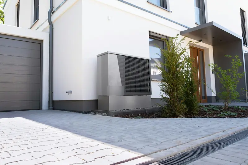 Maison avec une pompe à chaleur air/eau installée contre la façade